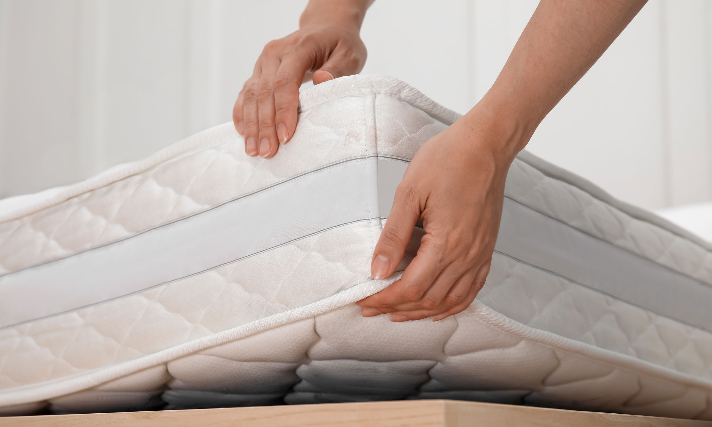 Une personne qui soulève un matelas.